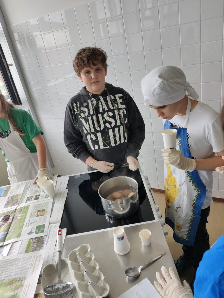 Kinder der 2b Klasse färben Ostereier in der Küche.